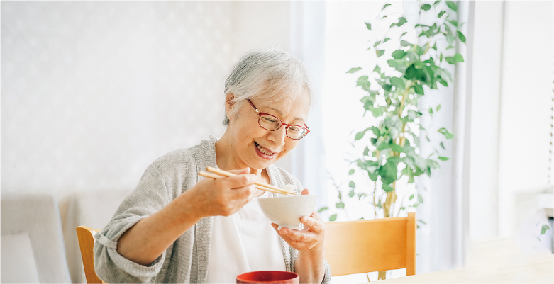 白髪の女性がご飯を食べている写真
